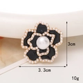 Vue détaillée de la broche camélia en émail noir 3,3x3cm avec perles et base dorée - Fleur De Perle Tout Noir