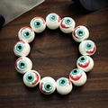Spooky Halloween eyeball bead bracelet with realistic veins and pupils on wooden surface - Eye