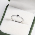 Macro view of silver adjustable ring with crystal-encrusted letter R in a green box - Platinum R