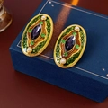 Primer plano de pendientes vintage ovalados con esmalte, perlas y detalles de cristal - Pin de plata-Verde