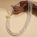 Détail d'un collier de perles multicouche avec pendentif fleur en résine sur branche de bois - Style Long Multicouches Blanc (83cm)