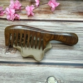 Handcrafted brown sandalwood massage comb with natural wood grain on a wooden base - 20cm Coarse Tooth Massage Comb