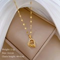 Macro-opname van gouden hartketting met Love-inscriptie en kristallen op zijden stof - Goud