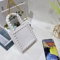 Dettaglio macro della borsa in gelatina di PVC bianco con rivetti alla moda e manico ad arco - Bianco