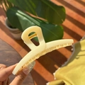 Detailed close-up of a 13.5cm cream resin butterfly hair claw clip with golden spring - Creamy Yellow