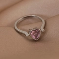 Gros plan détaillé d'une bague en argent sertie d'un cœur rose sur de la soie beige - 6#23157 Double Coeur