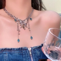 Silver butterfly fringe necklace with blue gemstones and shell sheen on model - Heavy Craft Butterfly Tassel Necklace
