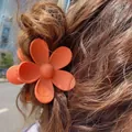 Matte orange flower hair claw clip for women styled on long wavy brown hair - 7cm / Orange