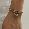 Bracciale minimalista con anelli intrecciati in oro e argento indossato su un polso - Bracciale a Catena a Tre Anelli Intrecciati in Acciaio Inossidabile