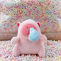 Pink plush Capybara keychain with blue bubble nose on colorful foam ball background - Runny Nose Pink + Bead Chain