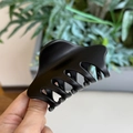 Détail rapproché de la pince à cheveux noire mate montrant sa charnière à ressort robuste - Noir mat