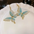 Macro detail of blue and white butterfly earrings with pearls on a ceramic dish - 1# Golden Blue Style