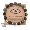 Green natural stone beaded bracelet with golden Evil Eye pendant on display card - 19cm / Variscite