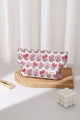 Detail of strawberry print toiletry bag on wooden tray with decorative lipstick - Large Strawberry