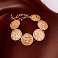 Detailed macro view of vintage gold coin bracelet with relief texture on silk fabric - Gold