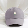 Gros plan d'une broderie de marguerite sur une casquette en coton de couleur mauve - Gris