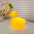 Cute yellow duck night light with blue ribbon bow on a cozy white desk background - Moe Yaya / Yellow - Blue
