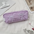 Detailopname van de lichtpaarse nylon etui met elegante witte geborduurde strikjes - Paars