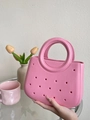 Borsa tote rosa in EVA con design traforato accanto a tulipani e una tazza - Rosa