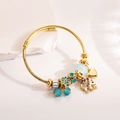 Gold adjustable spiral bangle featuring elephant heart charms and blue beads - Elephant
