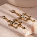 Macro shot of gold cross earrings with black crystals and white faux pearls detailing - S925 Silver Needle Drop Earrings / Gold Crown Cross