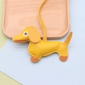 Macro detail of a yellow leather dachshund bag charm with high-quality litchi grain texture - Dachshund / Yellow