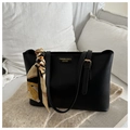Close-up of black leather tote bag featuring a decorative silk scarf and fashion engraving - Black