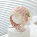 Nahaufnahme der rosa Strickmütze für Babys mit Spitzenborte und Strickkirschen - 3-15 Monate / Rosa