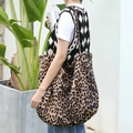 Trendy canvas draagtas met luipaardprint gedragen voor een modieuze casual look - Abrikoos