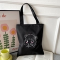 Detail of black oxford tote bag with cartoon girl print on an open book - Black with Winking Girl