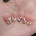 Close-up of nude press-on nails with colorful 3D flowers and water droplet decor - By1531 Flower Raindrops / Glue Type