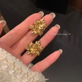 Golden flower earrings held by hand showing detailed floral design and size - Floral Shape Style (A2043金) / Gold