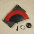Chinese red silk folding fan with black bamboo frame and tassel on vintage background - Red / 23CM
