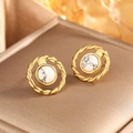 Detailed macro of gold twisted metal earrings with marble stones on jewelry box - Gold + White Turquoise