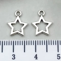 Pair of antique silver hollow star pendants on a ruler for size measurement comparison - Hollow Pentagram 10x12mm