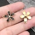 Flower charms set with black enamel and gold plating shown on fingertips for size - 1Pc Black Rhinestone Flower 17x20mm