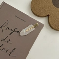 Close-up of elegant pearlescent white hair clip on a vintage book backdrop - No-Crease Hair Clips