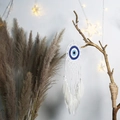 Detail eines handgefertigten Evil Eye Traumfängers mit weißen Federn und Perlen an Wand - Ms9424b Weiß / Wie abgebildet