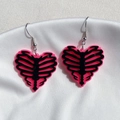 Orecchini a cuore in acrilico rosa con motivo a costine nere su seta bianca - Orecchini / Rosa nero