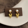Detail of baroque heart-shaped gold drop earrings with pearls on a wooden display - Style 26
