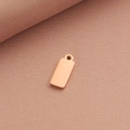 Vista macro de un colgante rectangular de metal oro rosa pulido y liso sin texto - Oro rosa