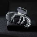 Eleganter silberner Haarklammer aus Metall mit Multi-Klauen-Design auf schwarzem Leder - Silber