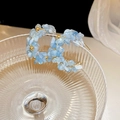 Macro shot of C-shaped hoop earrings featuring light blue stones and golden beads detailing - Silver Pin - Aquamarine C-Shaped Studs