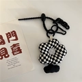 Detail of a black and white checkerboard flower charm with a white embroidered center - Black & White Checkerboard Flower