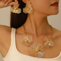 Elegantes Set aus goldener hohler Blumenkette und Ohrringen, getragen von einem Modell - Goldenes hohles Blumenohrring- und Halskettenset (03 Ohrringe + Halskette)