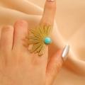 Detail of a vintage golden flower bone ring with a blue turquoise stone on finger - Turquoise Sun Pattern (9817)