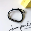 Dettaglio dell'elastico per capelli nero con perlina cilindrica in strass neri - Grigio