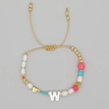 Adjustable beaded bracelet with white pearls, gold charms, and the letter W pendant - Letter W Style (ZZ-B24061901W-F)