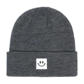 Close-up of dark grey knitted winter beanie featuring a smiley face patch detail - Deep Heather Grey