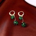 Detailed shot of emerald green spherical fringe earrings on luxurious red silk - Hoop Tassel Style / Gold with Green